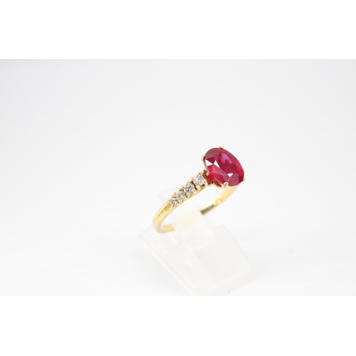 61 - An oval ruby and graduated brilliant cut diamond ring. Stamped 750. Size Q 1/2. Weight 3.23 grams