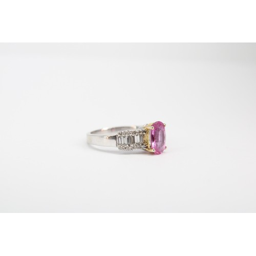63 - An oval pink sapphire dress ring with baguette and brilliant cut diamonds to each shoulder. Stamped ... 