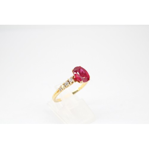 61 - An oval ruby and graduated brilliant cut diamond ring. Stamped 750. Size Q 1/2. Weight 3.23 grams