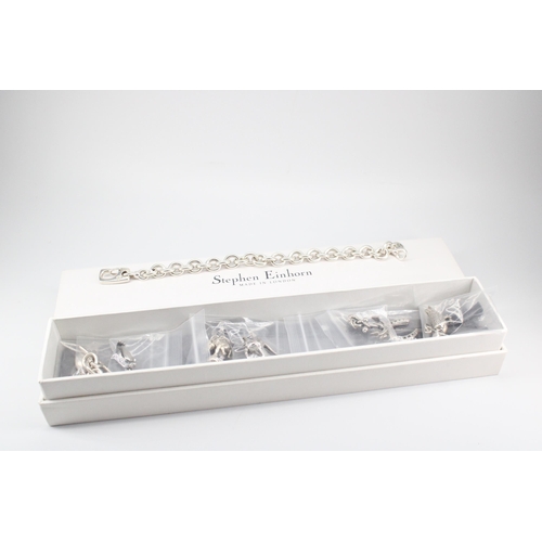 9 - A Stephen Einhorn sterling silver charm bracelet with 7 charms and spare links - charms to include L... 