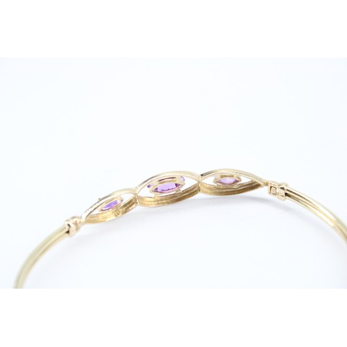 170 - A 14ct Tested Bangle, Featuring Three Central Marqu&eacute;s Cut Amethyst set within oval pierced pa... 