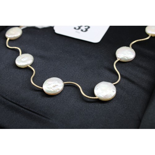 33 - A button pearl necklace. Length 460mm. Stamped 14K. Weight 16.71 grams