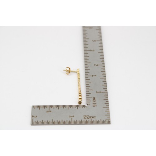 35 - A pair of graduated brilliant cut diamond line ear pendants. Length 32mm. Stamped 14ct. Weight 2.22 ... 