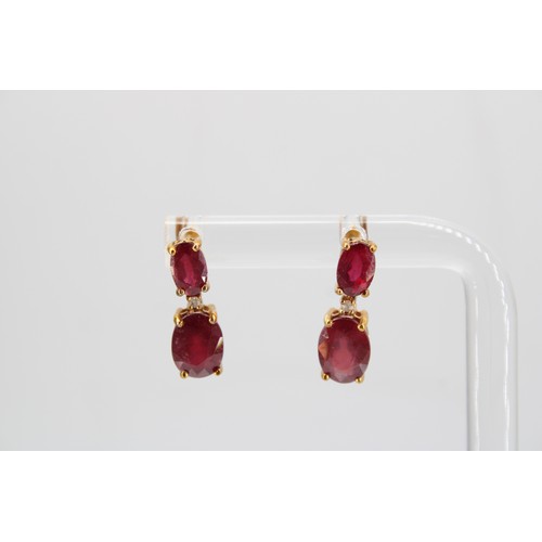 36 - A pair of glass filled ruby and diamond ear pendants. Length 16mm. Stamped 10K. Weight 2.38 grams