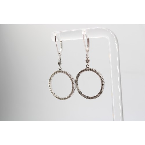 39 - A pair of diamond circle ear pendants. Length 40mm. Stamped 10K. Weight 3.11 grams