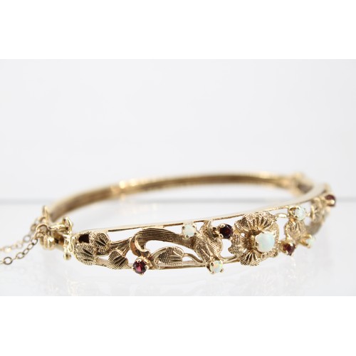 32 - A 9ct Opal & Garnet Bangle with Pierced Floral Panel&nbsp;Weight: 14.30g Internal Diameter: 6.5c... 