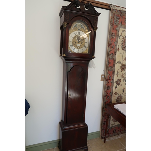  An 8 day mahogany grandfather clock with a brass face and moonroller dial with a plaque signed Geo M... 