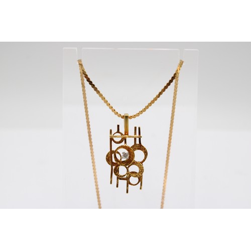 2 - An abstract line and circle pendant set with a brilliant cut diamond. Length 35mm. Stamped 18KT. Wei... 