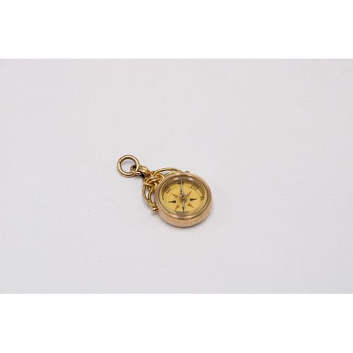 3 - A 9ct gold compass charm. Weight 7.57 grams