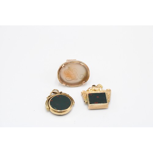  Three 9ct gold-mounted fob seals, late 19th and early 20th centuries, the first a bloodstone and car... 