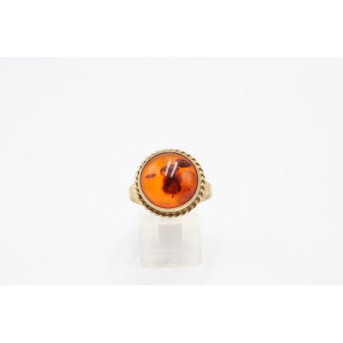 31 - An 8ct gold and amber ring, marked 333, cabochon cut, rope twist border, size P, weight 3.38g
