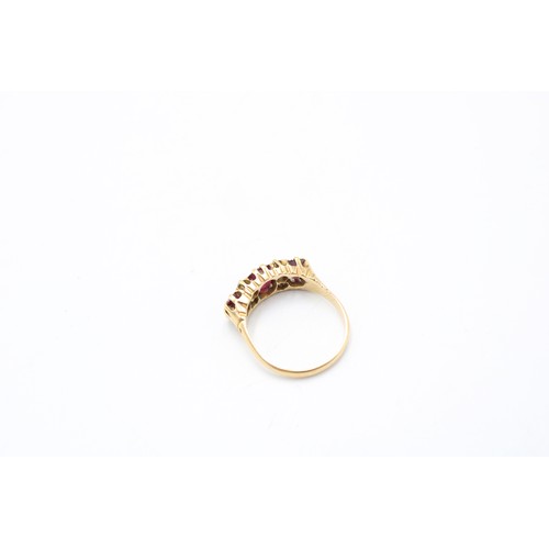  An 18ct gold, ruby and diamond ring, Birmingham, 1901, the three cushion cut rubies within four roun... 
