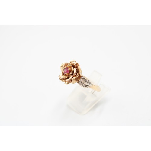  A 14ct gold flower ring with ruby centre and diamond set shoulders. Size S. Weight 7.63 grams