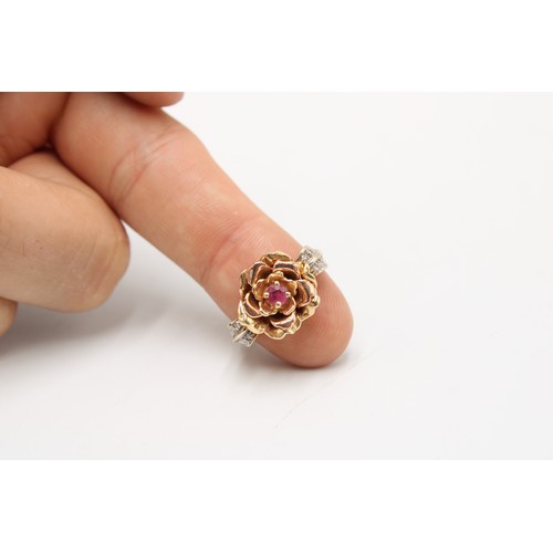  A 14ct gold flower ring with ruby centre and diamond set shoulders. Size S. Weight 7.63 grams