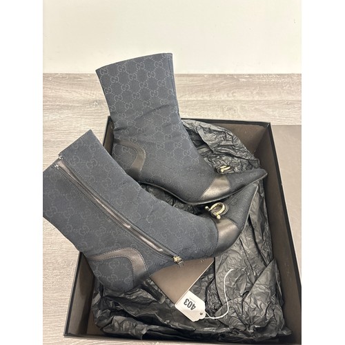  A pair of Gucci 'Ascot' ankle boots, early 2000s, leather trimmed black GG logo canvas with brass fi... 