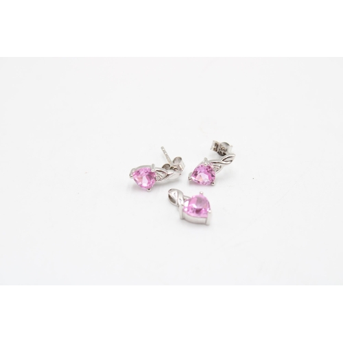  A 9ct gold pendant and earring set composed of a heart shape pink sapphire and diamond highlight. We... 