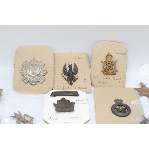 447 - A collection of twenty First and Second World War cap badges and medals, British and Canadian, inclu... 