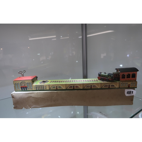 481 - A tin wind-up train, German, 1930s-1950s, with lithographed track, locomotive and station buildings,... 