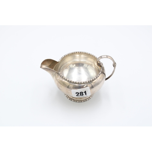  A silver cream jug, Walker & Hall, Sheffield, 1929, scroll handle, bead and spindle borders, len... 