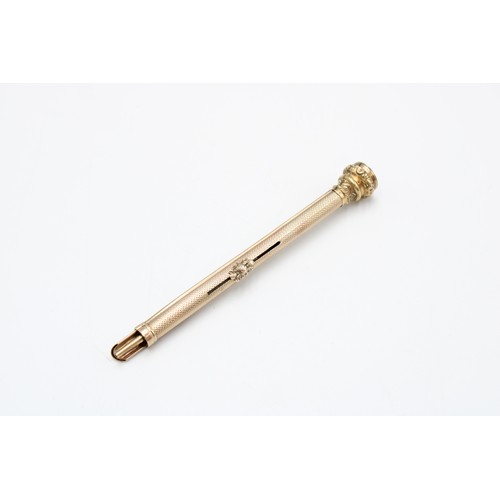  A 9ct gold tested propelling pencil, early 20th century, engine-turned surface, the cap chased with ... 