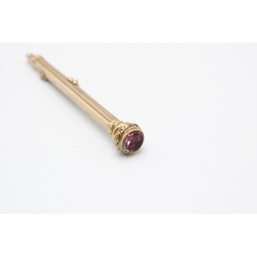  A 9ct gold tested propelling pencil, early 20th century, engine-turned surface, the cap chased with ... 