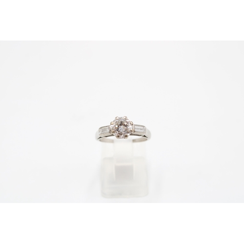  A brilliant cut diamond ring with a baguette diamond to each side. Estimated principal diamond weigh... 
