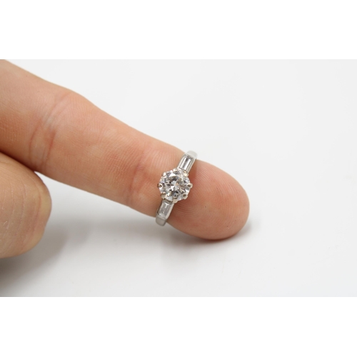  A brilliant cut diamond ring with a baguette diamond to each side. Estimated principal diamond weigh... 
