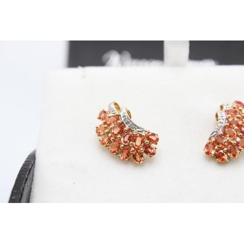 140 - A pair of 9ct gold orange sapphire and diamond earrings. Length 18mm. Weight 4.14 grams