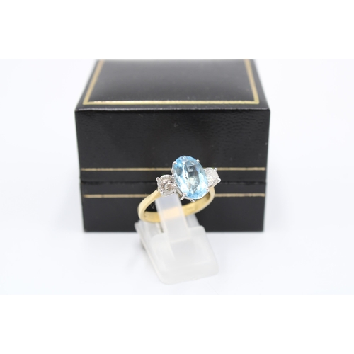  An 18ct gold oval aquamarine and brilliant cut diamond three stone ring. Size P. Weight 4.64 gramsCo... 