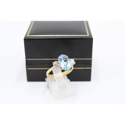  An 18ct gold oval aquamarine and brilliant cut diamond three stone ring. Size P. Weight 4.64 gramsCo... 