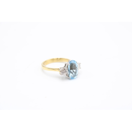  An 18ct gold oval aquamarine and brilliant cut diamond three stone ring. Size P. Weight 4.64 gramsCo... 