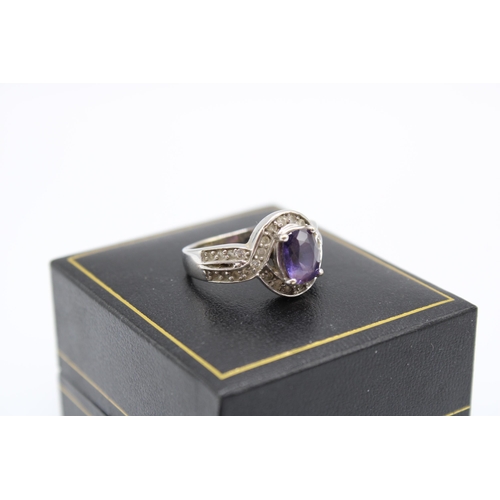  A purple sapphire and diamond cluster ring. Size P 1/2. Stamped 18K. Weight 5.60 grams.Condition: Go... 