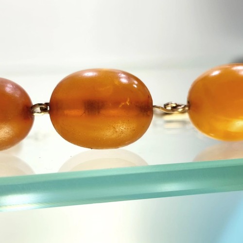 138 - Antique Amber Necklace: Graduated amber beads with 9ct gold clasp (hallmarked 375). Likely 1950s. Le... 