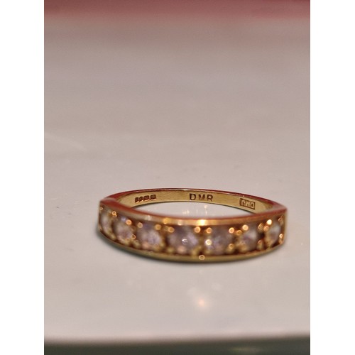 156 - 18ct gold ring adorned with seven diamonds. Size R and 2.8grams gross. Stamped with London hallmark ... 