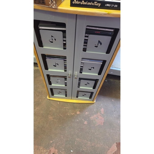 117 - A Collection of Music CDs Housed within a Two-Tier Wooden and Metal Storage Cabinet