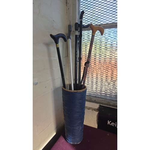 363 - A Group of Five Walking Canes and a Forearm Crutch in a Woven Stand