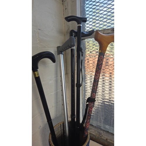 363 - A Group of Five Walking Canes and a Forearm Crutch in a Woven Stand