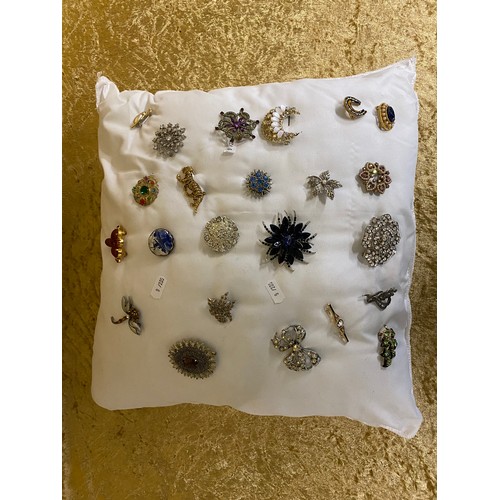 4 - A Cushion of 23 assorted brooches