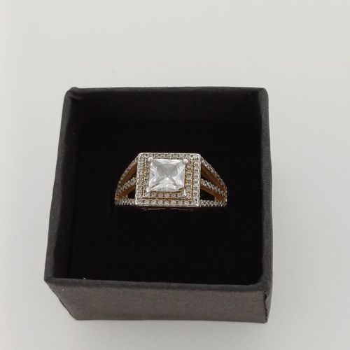 22 - Silver Ring with a square cut center stone with encrusted stones around.

Size M