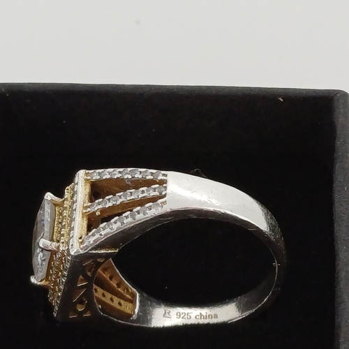 22 - Silver Ring with a square cut center stone with encrusted stones around.

Size M