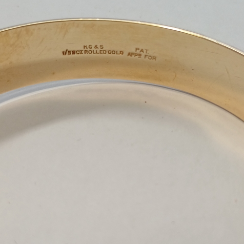 235 - A One Fifth 9ct Gold Bangle with decoration one side and safety chain