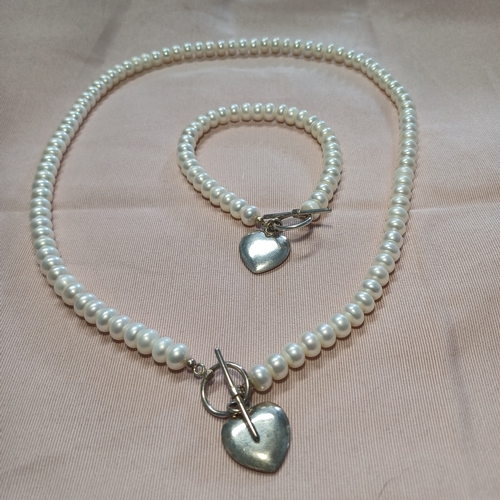 240 - A Natural Pearl Necklace and Bracelet Set with a Silver Heart and Loop Catch.