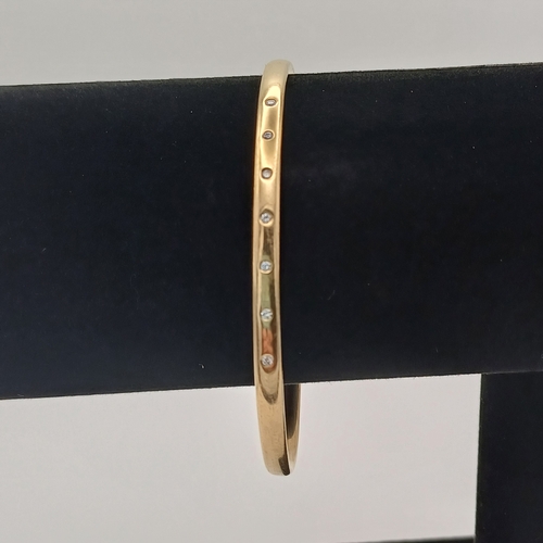 13 - A very lovely Gold Bangle with inset Diamonds.
- weight 15.65g
- 9ct yellow gold