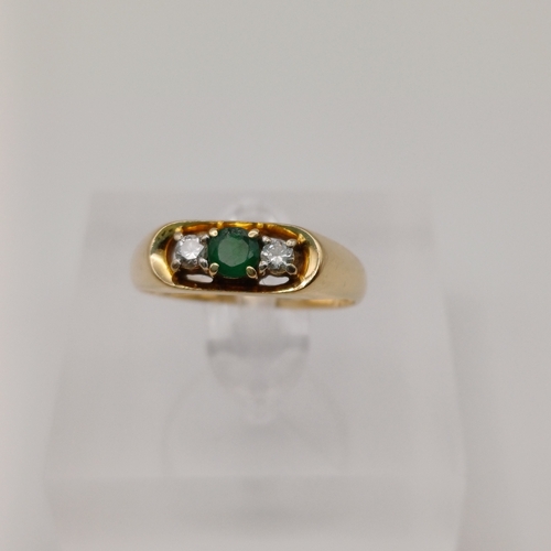 25 - A Three Stone Emerald and Diamond Ring. In an unusual setting and the Emerald is really beautiful de... 