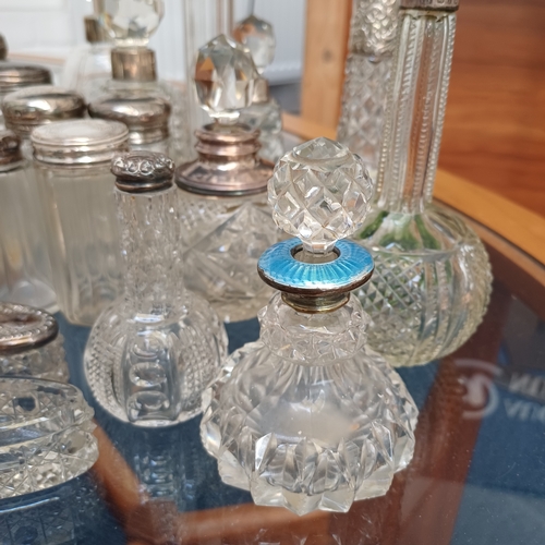 100 - A mixed set of cut glass/crystal vanity bottles the majority with stoppers all, save a couple, have ... 