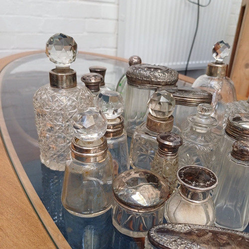 100 - A mixed set of cut glass/crystal vanity bottles the majority with stoppers all, save a couple, have ... 