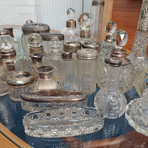 100 - A mixed set of cut glass/crystal vanity bottles the majority with stoppers all, save a couple, have ... 