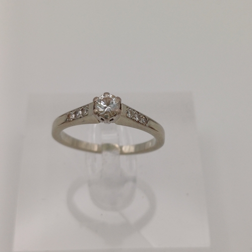 24 - A Solitaire Diamond Ring with three small diamonds set into the shoulder of the shank each side
- 18... 