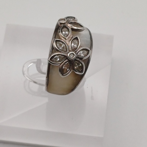 65 - Wide Silver Coloured Metal Ring very attractive with a flower design and white stone
- weight 6.32g
... 