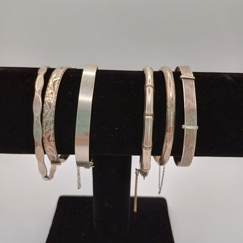 124 - Six Silver Bangles:
- 4 x hinged
- 1 slip on 
- 1 x expanding

All are marked either 925 or are hall... 